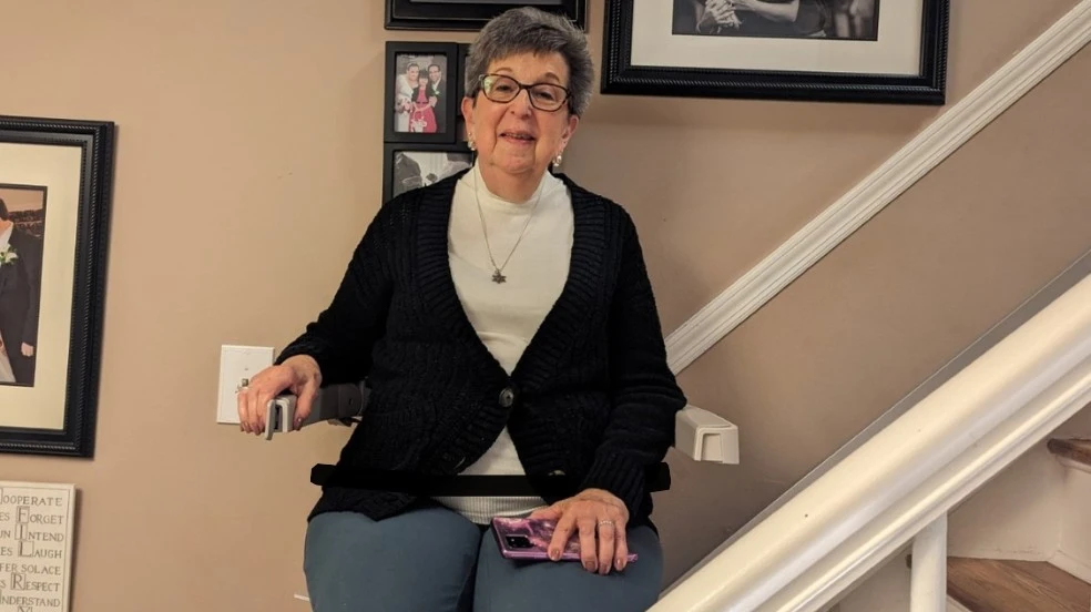 a woman riding an indoor stair lift