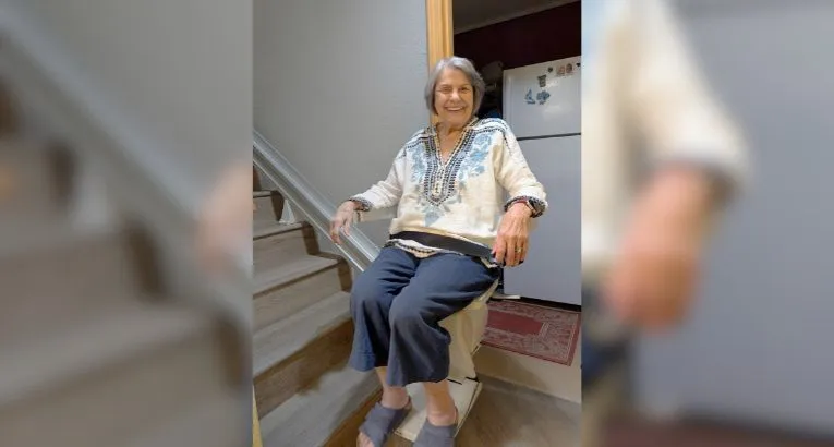 a woman riding an indoor stair lift