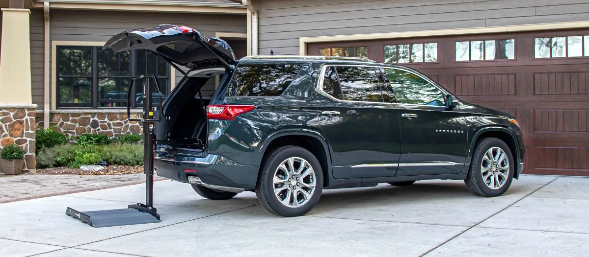a scooter lift unfolded behind a black suv