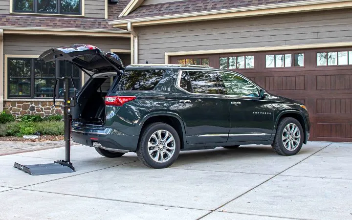 a scooter lift unfolded behind a black suv