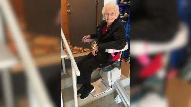 a woman riding a stair lift