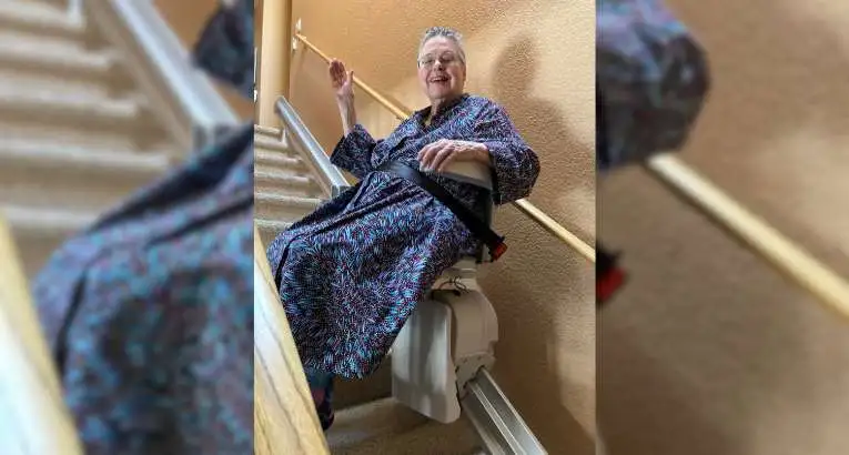 a woman riding an indoor stair lift