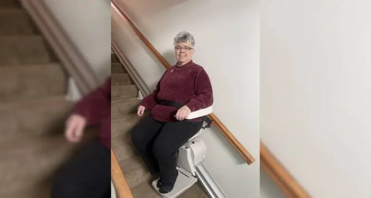 a woman riding an indoor stair lift