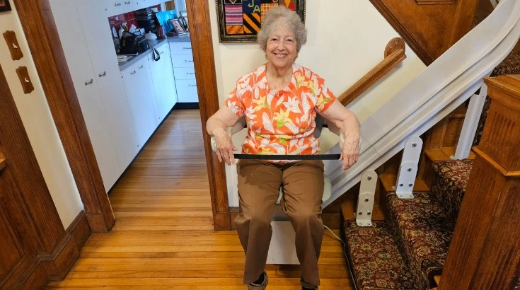 a woman riding an indoor stair lift