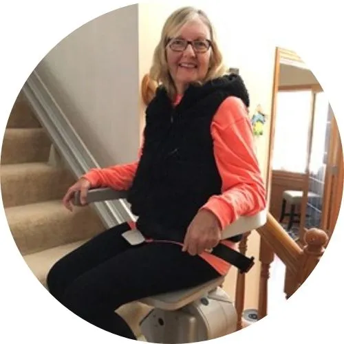 a woman riding an indoor stair lift