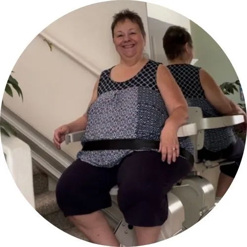 a woman riding an indoor stair lift