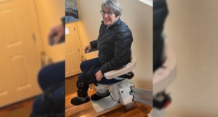 a woman riding an indoor stair lift