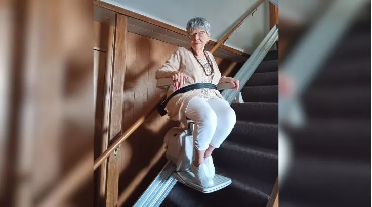 a woman riding an indoor stair lift