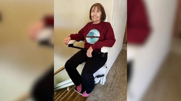 a woman riding an indoor stair lift