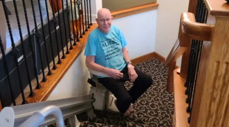 a man riding an indoor stair lift