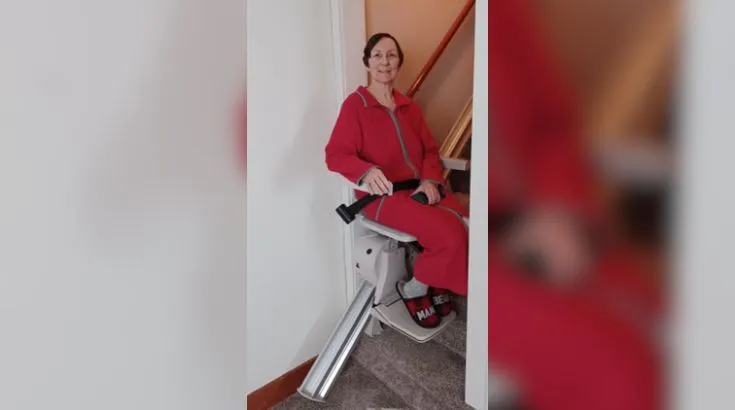 a woman riding an indoor stair lift