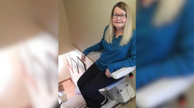 a woman riding an indoor stair lift