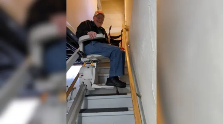 a woman riding an indoor stair lift