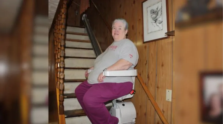 a woman riding an indoor stair lift